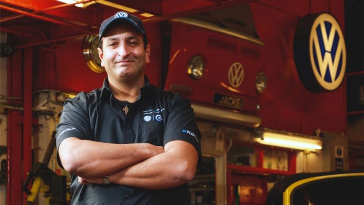 The Jack's Garage owner in the workshop in front of a classic VW Bus